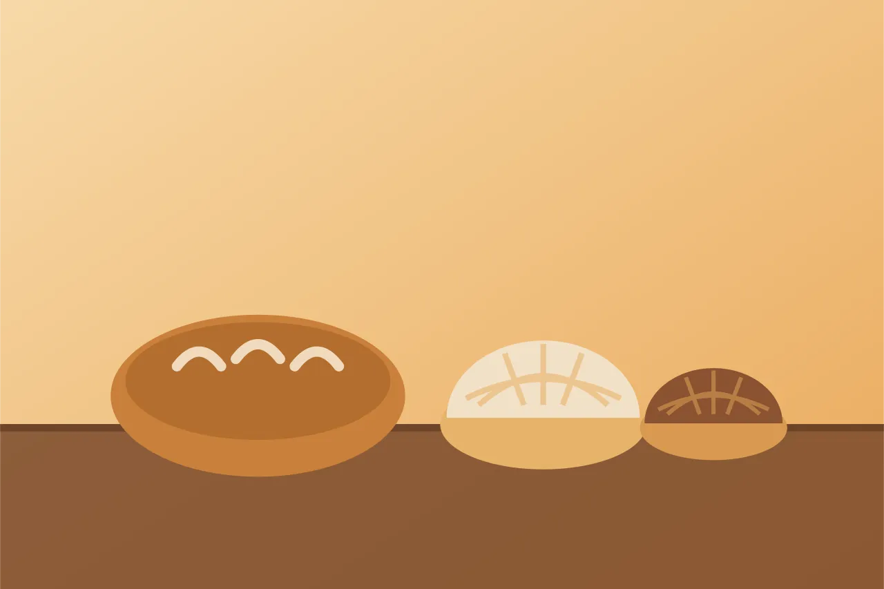 Hogaza de pan y dos conchas sobre el mostrador de madera de la panadería