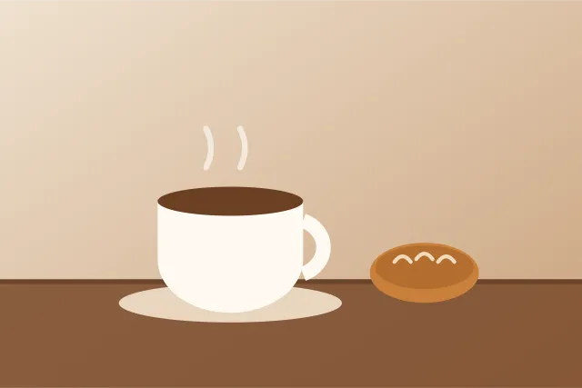 Taza de café junto a una pieza de pan